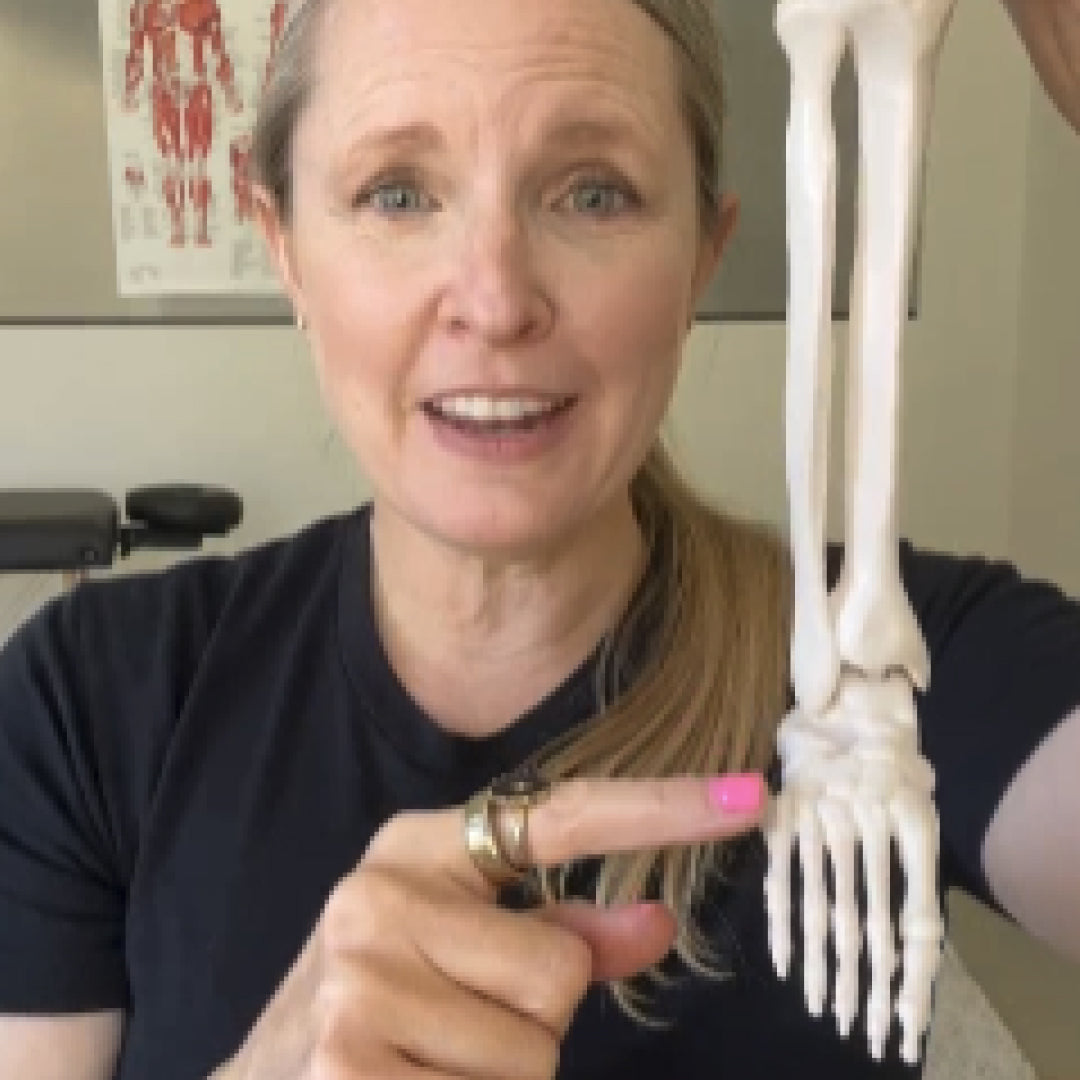 Woman pointing to a skeleton model of a foot with text 'FOOT PAIN' above her.