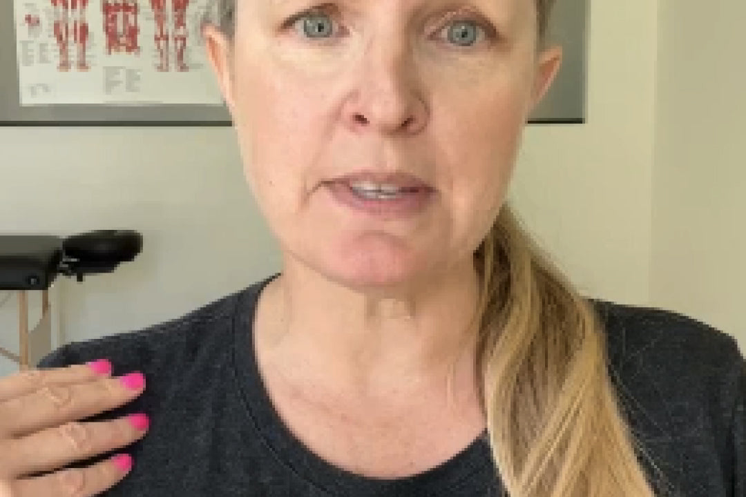 Woman with upper trap pain holding her shoulder